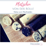 Vier Rollen Keksteig in unterschiedlichen Varianten auf einem Holzbrett auf dunklem Untergrund. Text: