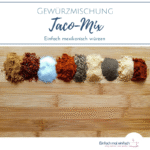 Taco-Gewürze in einer Reihe auf hölzernem Schneidbrett. Text:"Gewürzmischung Taco-Mix. Einfach mexikanisch würzen"