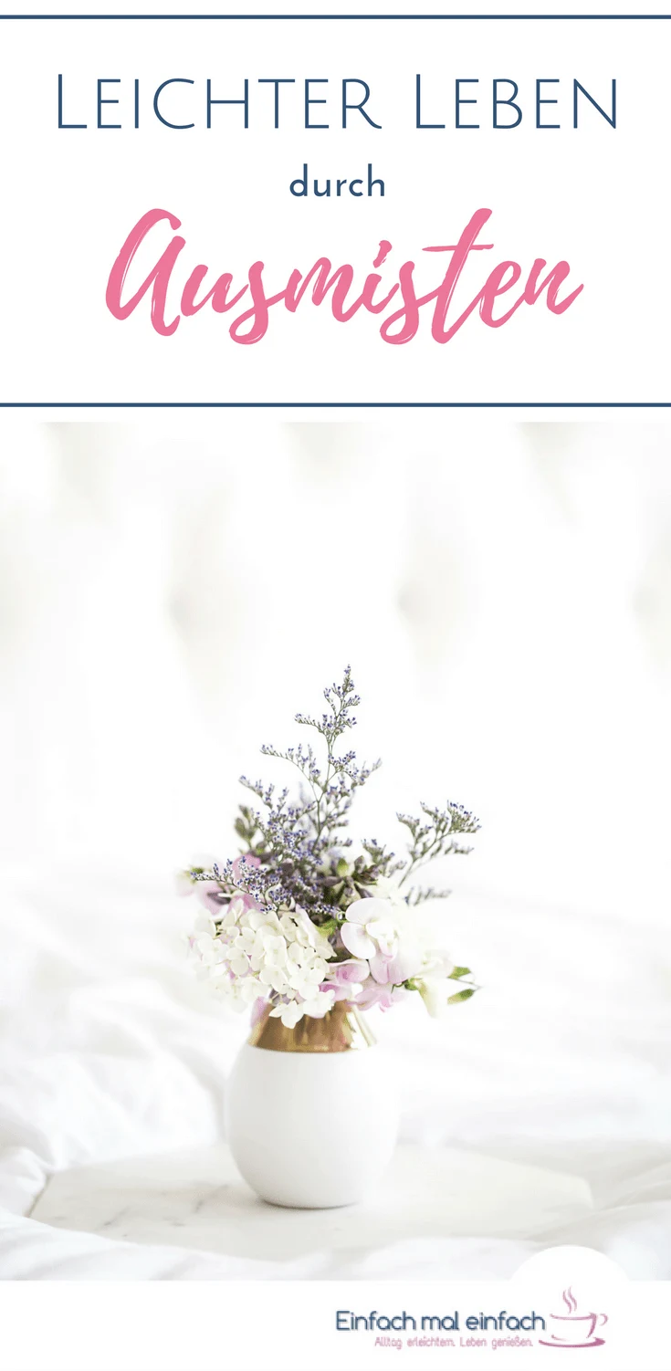 Weiße Vase mit lila und weißen Blumen auf Marmortablett vor hellem Hintergrund. Text:"Leichter Leben durch Ausmisten"